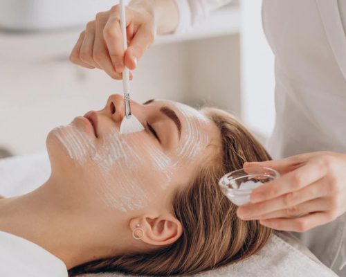 cosmetologist-doing-face-treatment-applying-face-mask_1303-28042